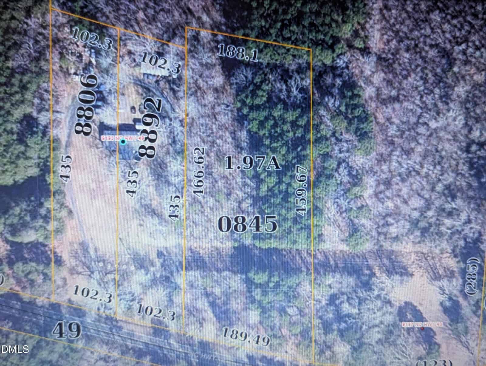 Aerial view of a wooded property map showing marked lot boundaries, numbers, and measurements. Two labeled plots (8806, 8892) are on the left, a central lot (0845) is marked 1.97A, surrounded by forest and clearings.