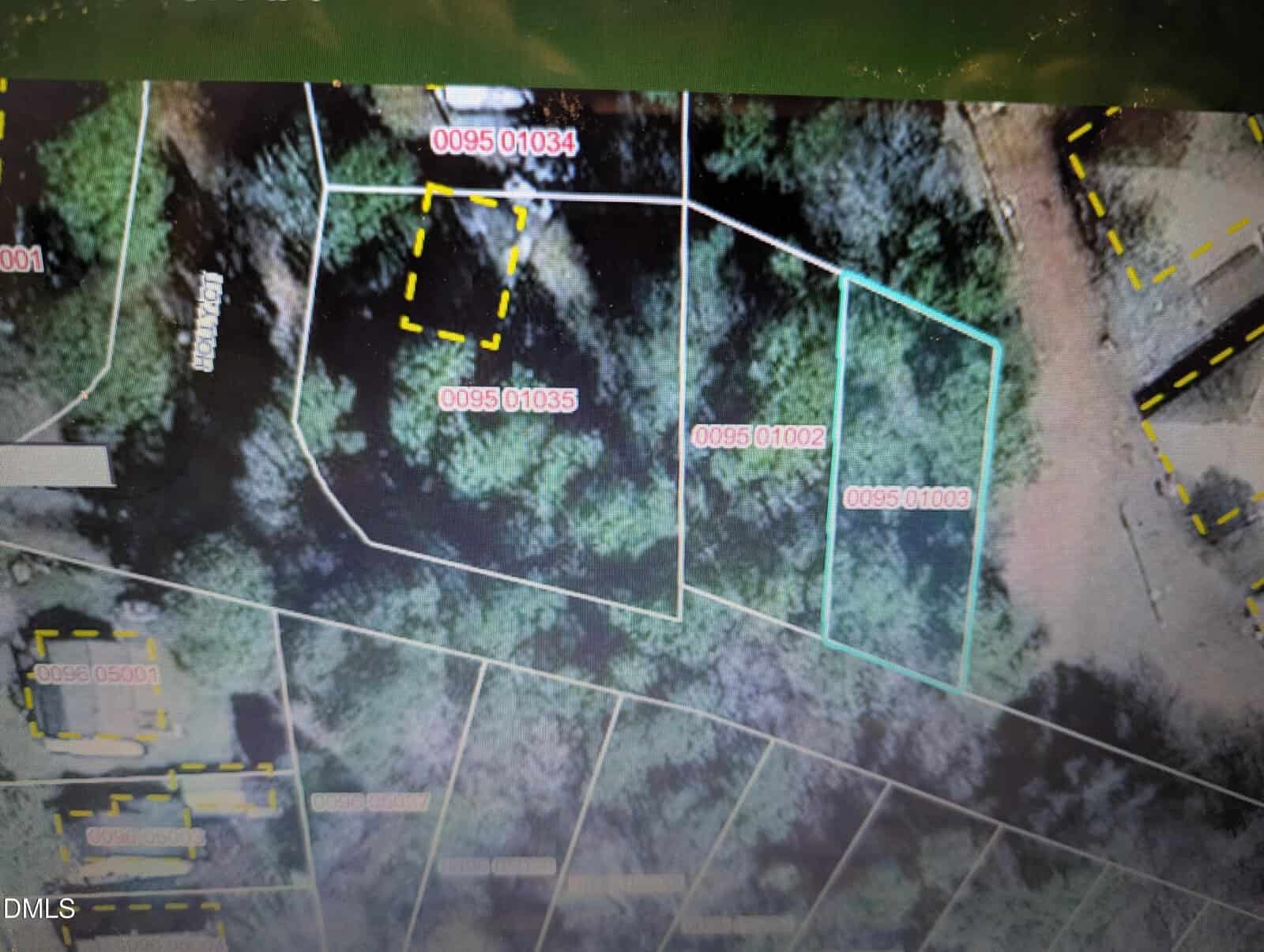 Aerial map view showing several wooded property plots outlined in white and blue with labeled parcel numbers (e.g., 0095 01034, 0095 01035, 0095 01002, 0095 01003) and yellow dashed boundary lines.