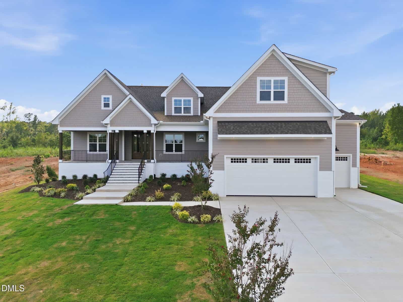 A modern two-story house with gray siding, white trim, a covered front porch, three-car garage, and landscaped yard sits on 45 Peaceful Drive in Franklinton, set against a clear blue sky and green lawn.