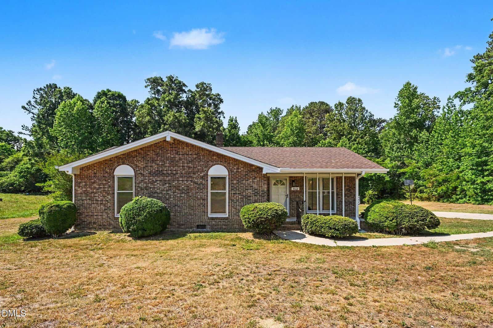 Charming single-story brick house in Oxford at 3662 W Antioch Drive, featuring a gable roof, arched windows, and a covered front porch, surrounded by shrubs and trees with a dry, patchy lawn in the foreground.