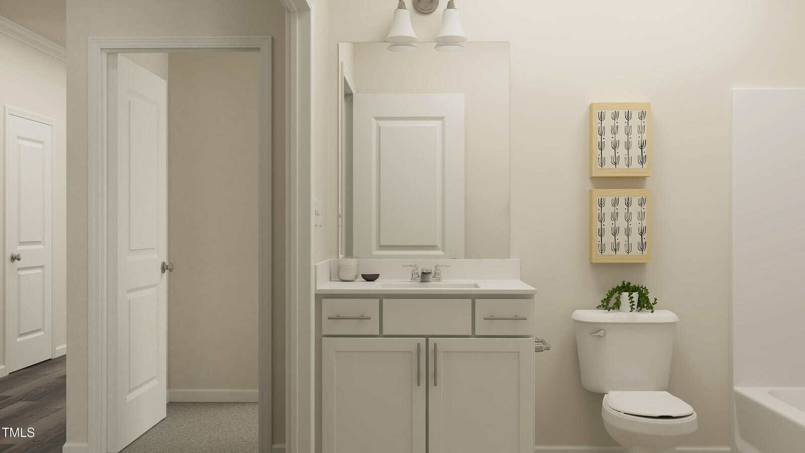 A modern bathroom with a white vanity, mirror, and light fixture. A toilet with a small plant on top is next to framed art on the wall. Two open doorways are visible, showing adjacent rooms.
