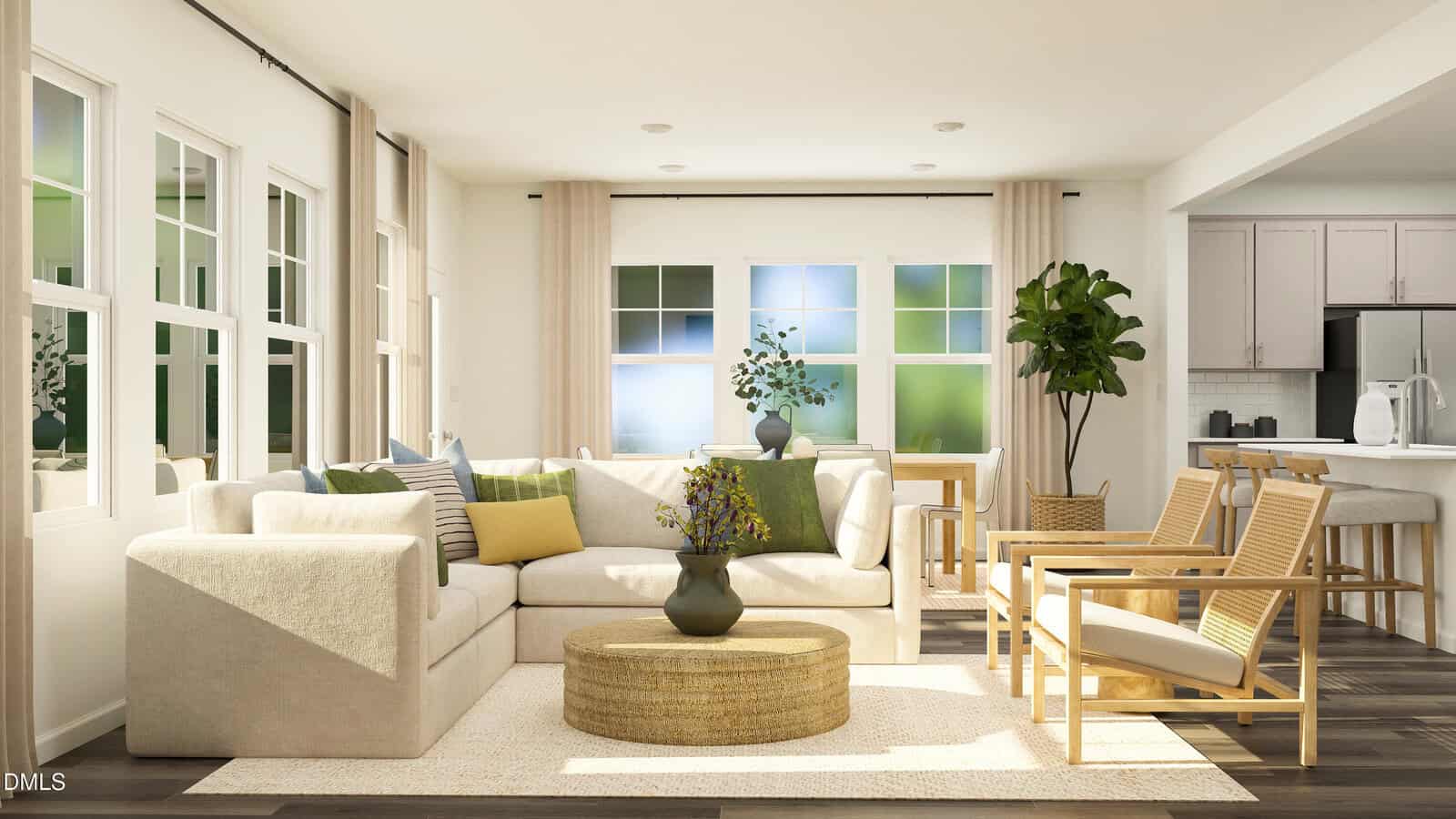 A bright living room with a cream sectional sofa, wooden chairs, a round coffee table, indoor plants, and large windows. A kitchen with white cabinets is visible in the background.