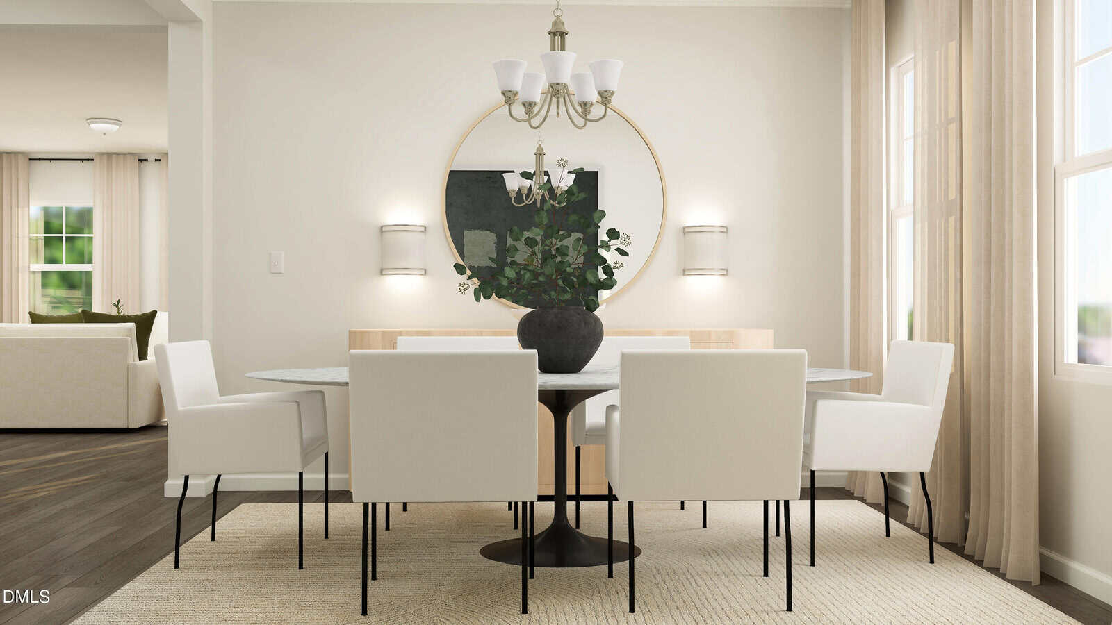 Modern dining room with a round table, six white chairs, a large circular mirror, potted greenery centerpiece, chandelier, beige rug, and natural light from windows with cream curtains. Living room visible in background.