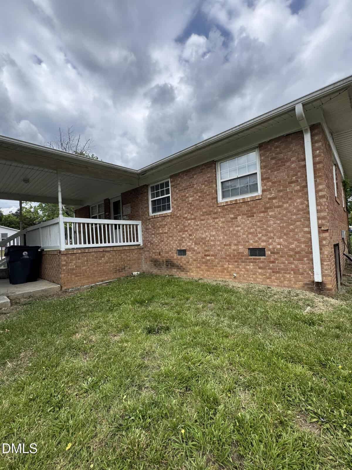 A single-story brick house with white trim and a covered front porch sits at 117 Ward Avenue, Oxford. The yard is grassy, and the sky is cloudy. There are two visible windows and a small staircase leading to the porch.