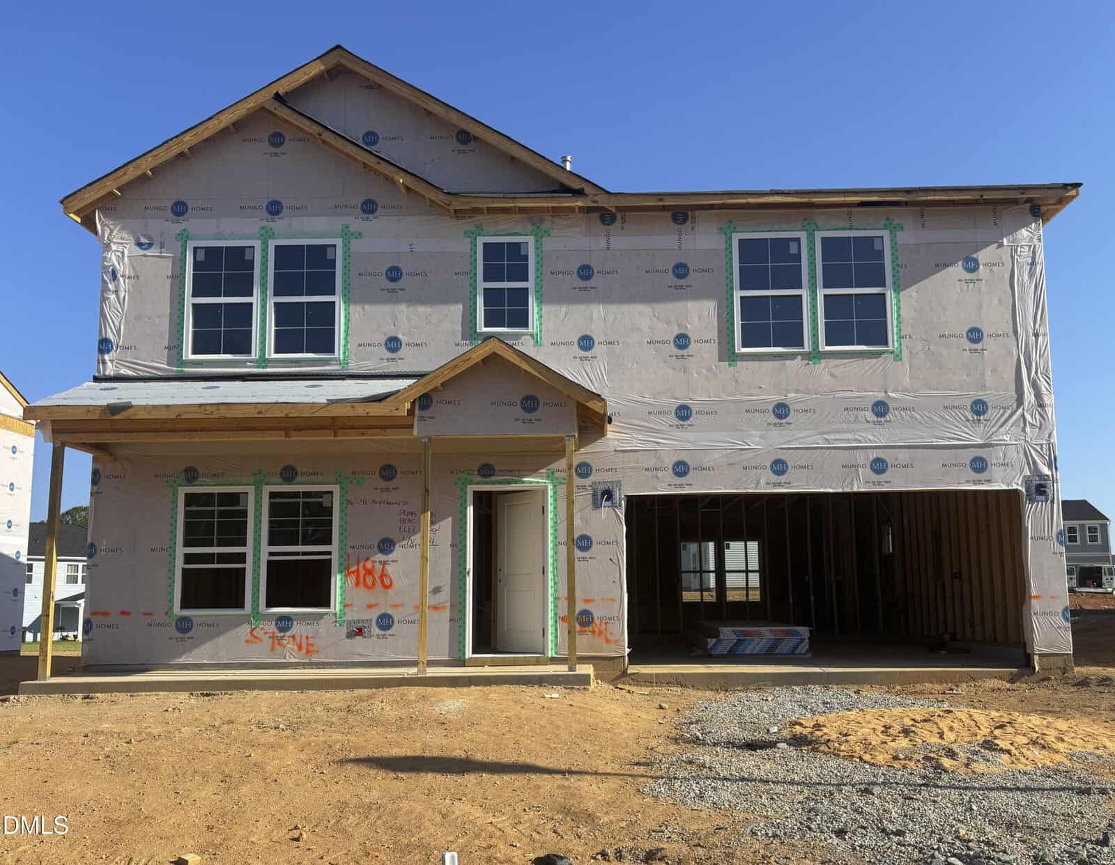 A two-story house under construction at 41 Mistflower Drive in Youngsville, wrapped in protective material with exposed windows, door frames, and an open garage. The ground is dirt and gravel, and nearby houses are visible in the background.