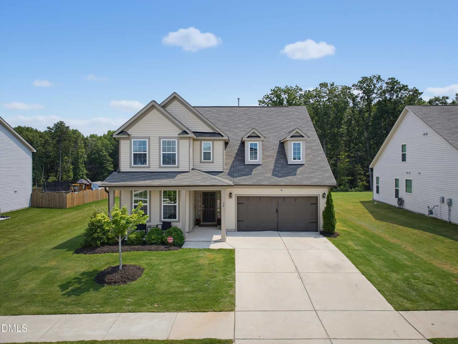 Two-story suburban house with light-colored siding, dark roof, and attached two-car garage located at 90 Glendavis Hollow Drive in Franklinton. Concrete driveway leads to the garage. Well-kept lawn and small landscaping in the front yard. Neighboring homes visible on both sides.