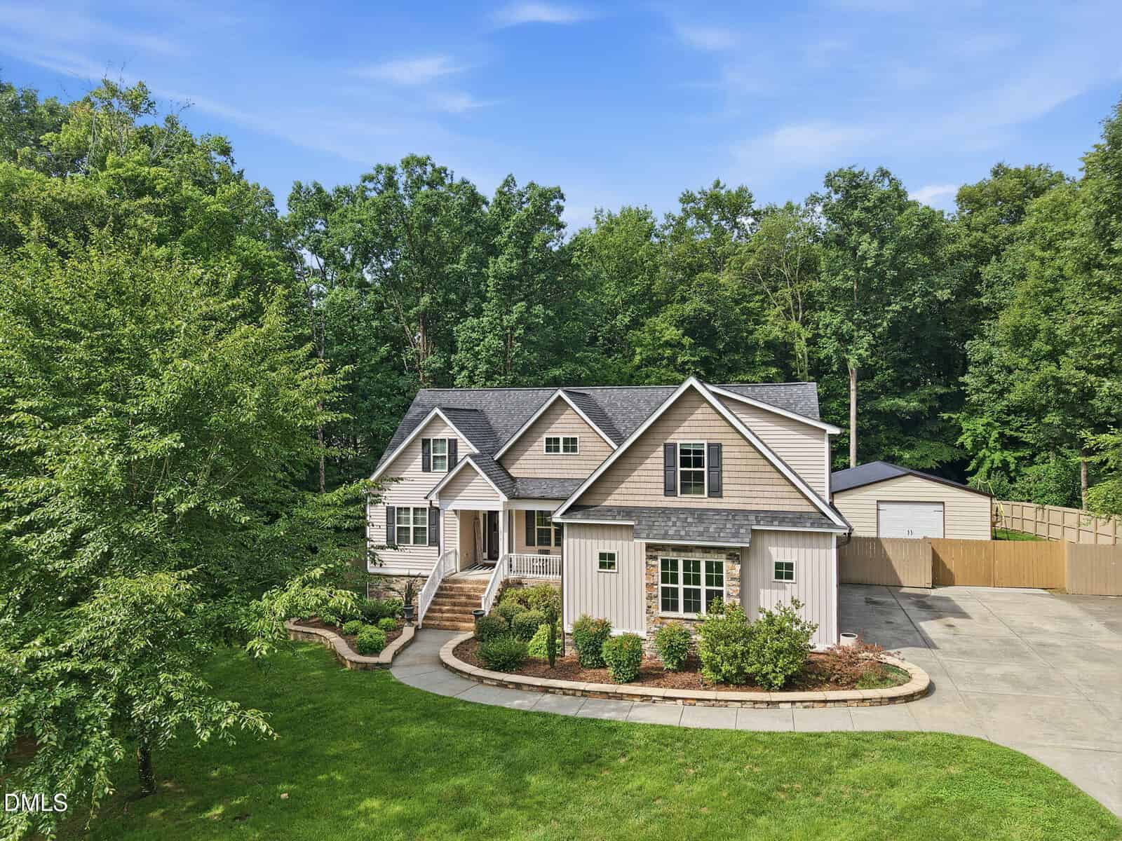A two-story house with light-colored siding, a gray roof, and a covered front porch sits on 1096 Buggy Lane in Stem. There is a driveway, manicured lawn, landscaped bushes, and trees in the background. A detached garage is visible to the right.