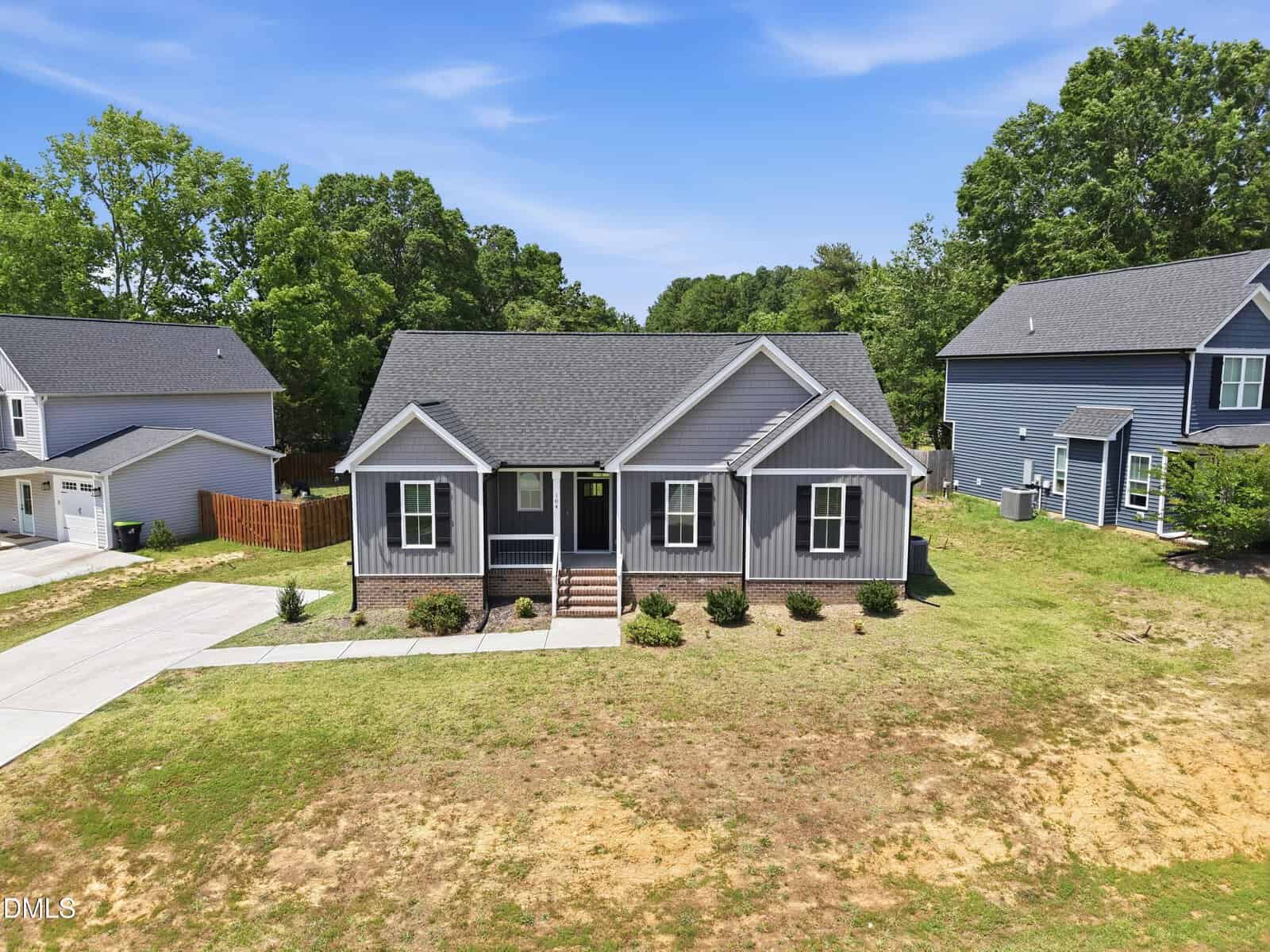 A gray single-story house with white trim, a covered front porch, and a neatly landscaped yard sits at 104 Averly Court in Stem, surrounded by other homes and trees under a blue sky.