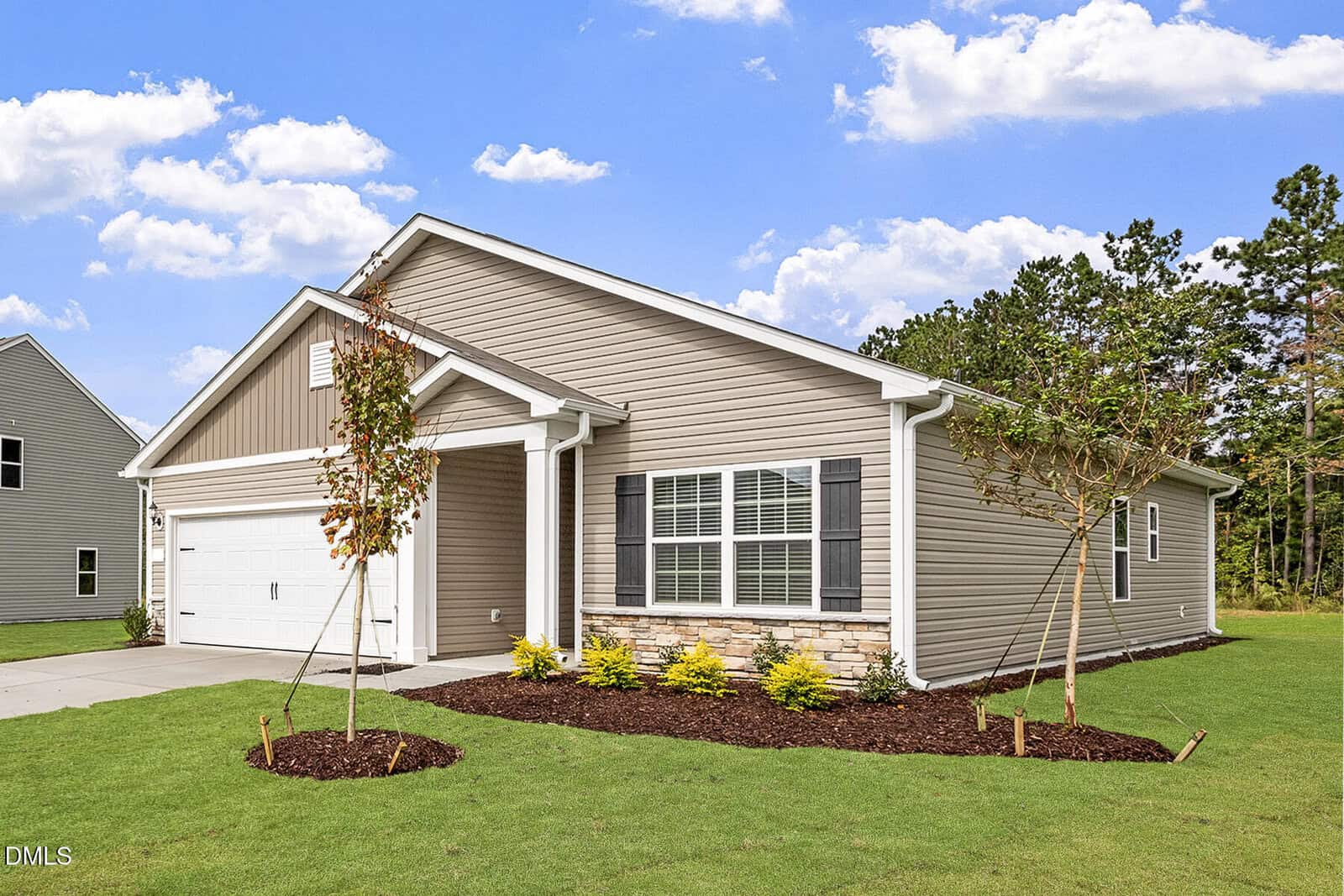 Charming single-story beige house with white trim, located at 1018 Rhino Bend in Oxford. Featuring a welcoming front porch, attached two-car garage, manicured lawn, young trees, shrubs, and a blue sky with scattered clouds.