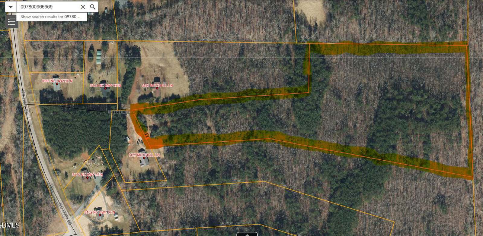 Aerial map view of a wooded area in Oxford showing property boundaries in orange, with houses and driveways—including 0 Mitchell Lane—labeled roads, and dense tree coverage. A search bar appears at the top left corner of the image.