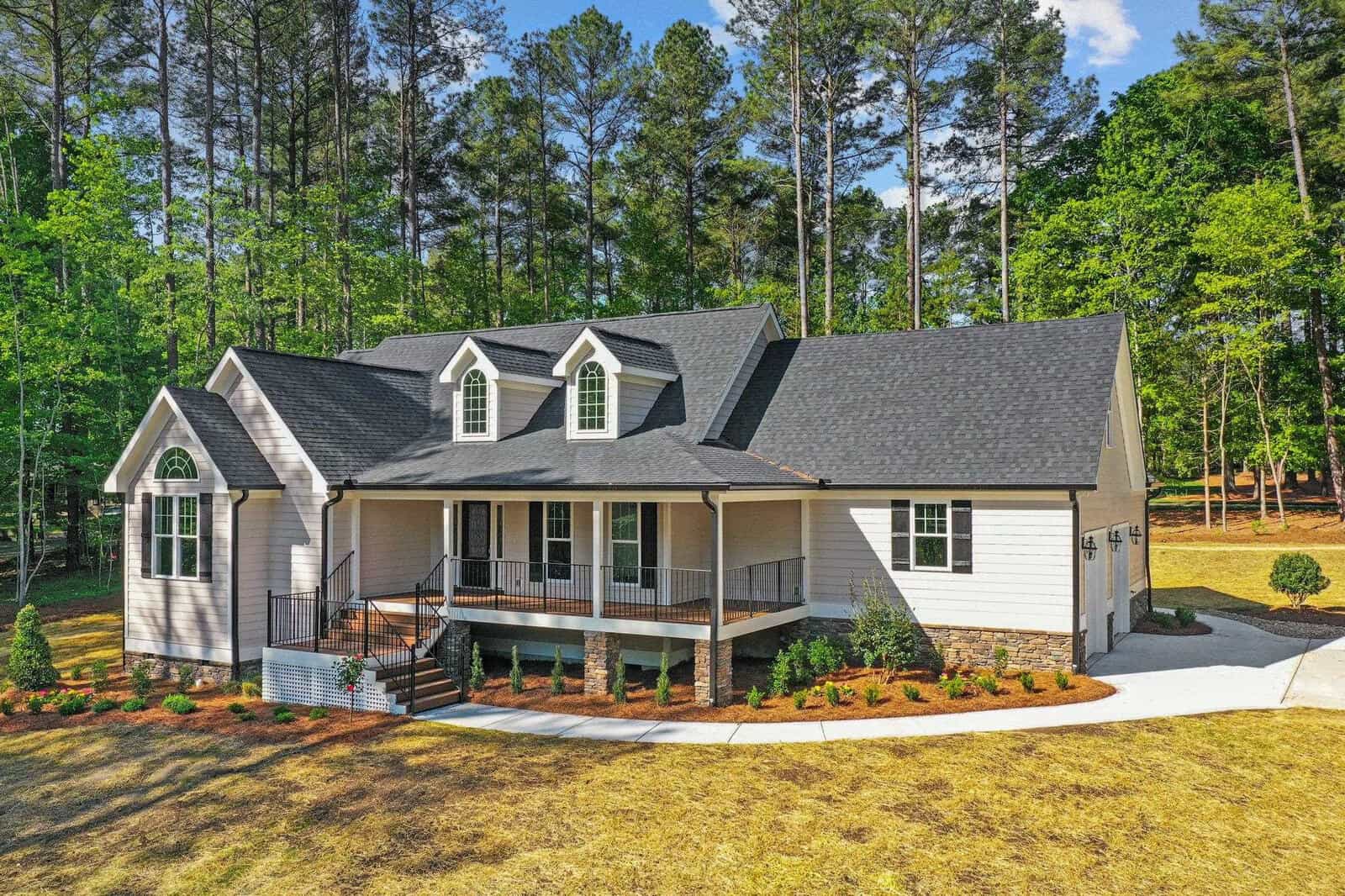 A single-family house at 3325 Cameron Drive, Henderson NC, with a gray exterior, white trims, and a front porch, surrounded by a landscaped lawn and located in a wooded area