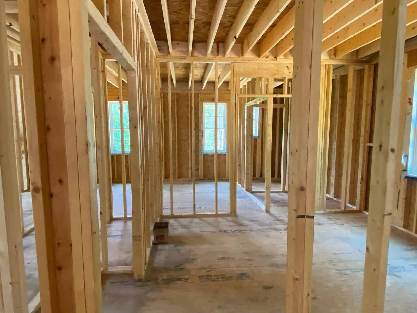 Interior framework of a house under construction with visible wooden studs and partition walls.