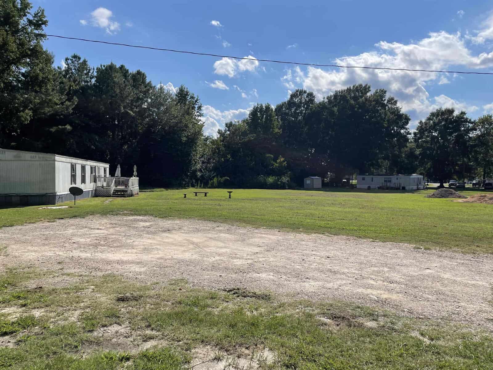 A dirt road with a trailer in the background.