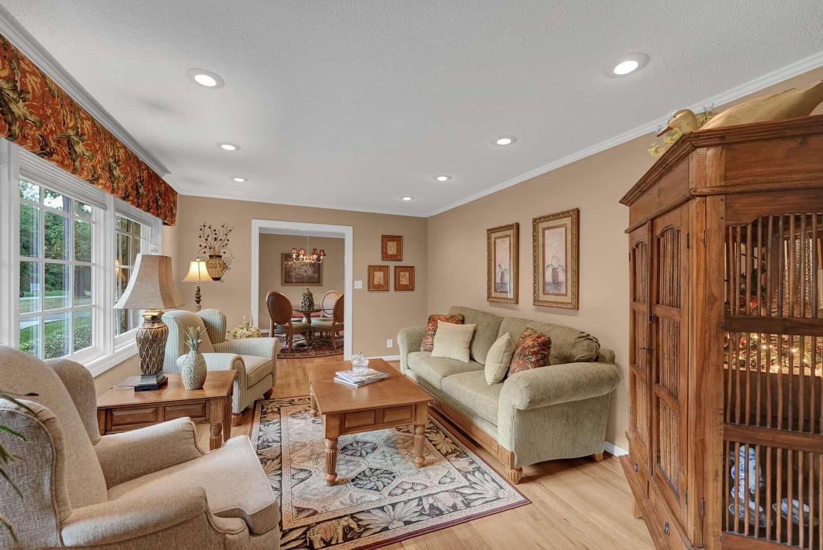 A well-lit, traditional living room with comfortable seating, a wooden coffee table, and a large birdcage.
