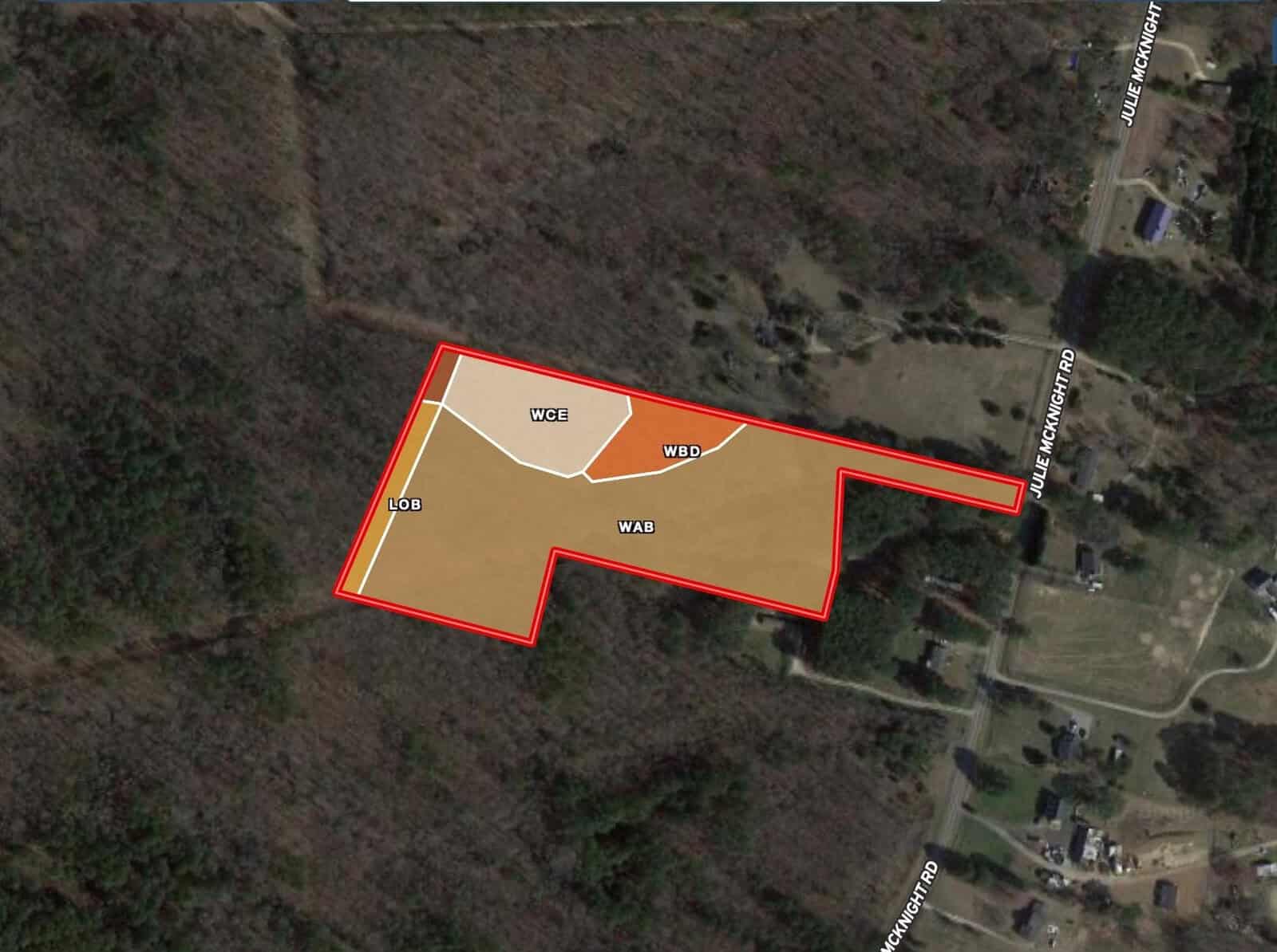 Satellite view of a forested area with a highlighted plot outlined in red. The plot is subdivided into four sections labeled WCL, WBD, LOB, and WAB. The area is adjacent to Julie McKnight Road and Montgomery Road in Kittrell. Nearby residential structures are visible.