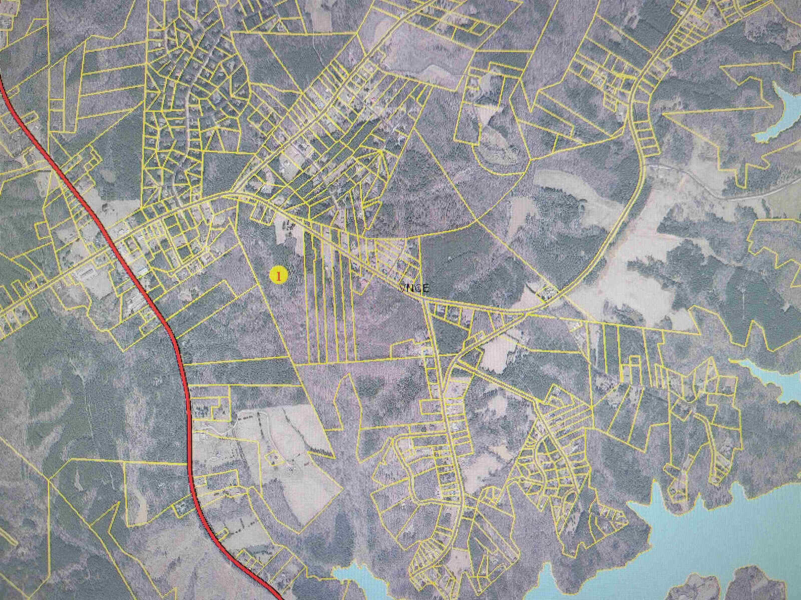 A detailed map showing an urban area with streets, water bodies, and various land parcels in different shades.