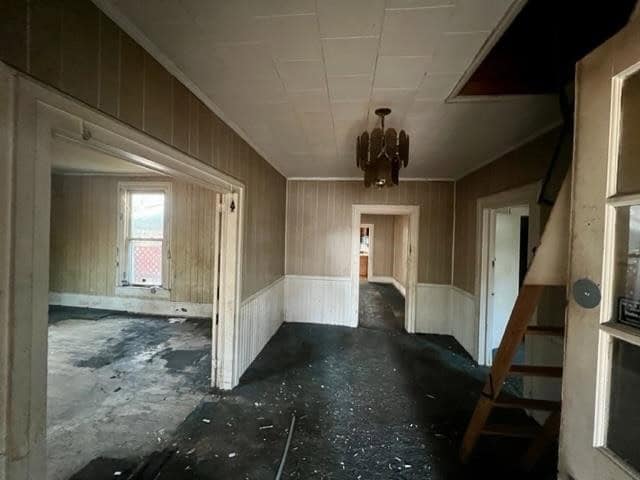 Interior of a neglected room showing signs of deterioration, with debris on the floor, damaged walls, and an abandoned appearance.