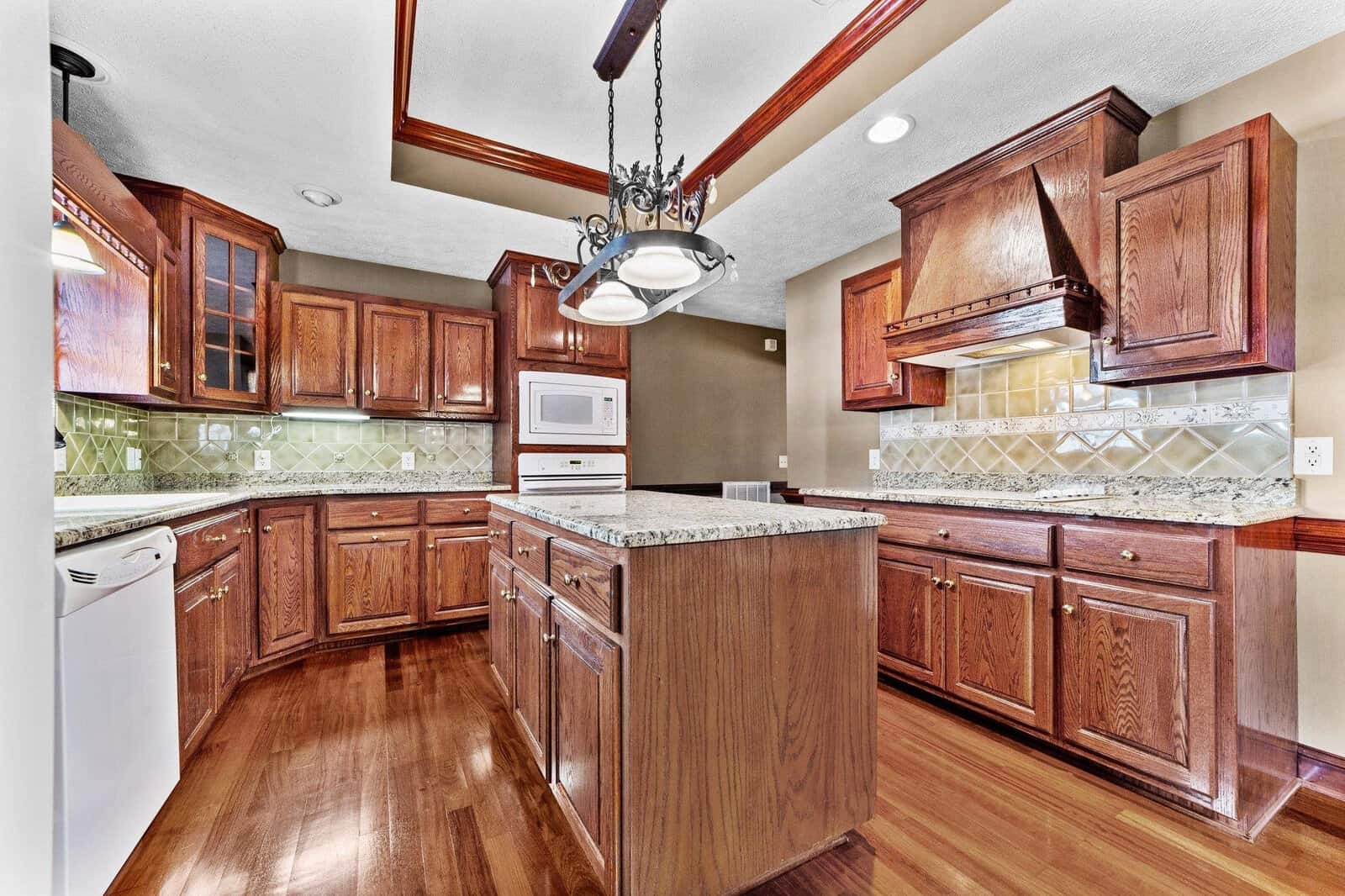 A modern kitchen with rich wooden cabinetry, stainless steel appliances, and hardwood flooring.