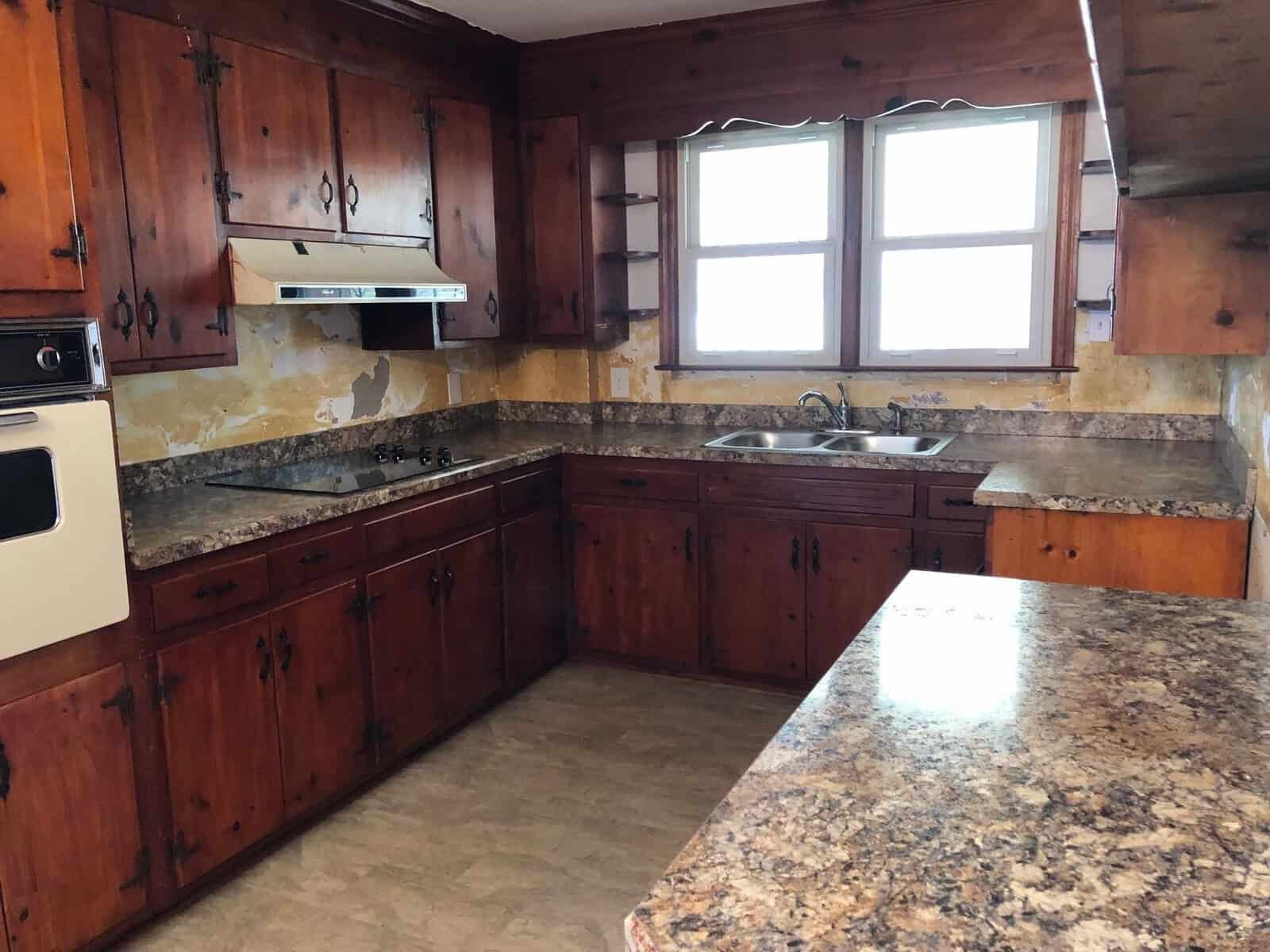 A kitchen with wooden cabinets, granite countertops, and built-in appliances.