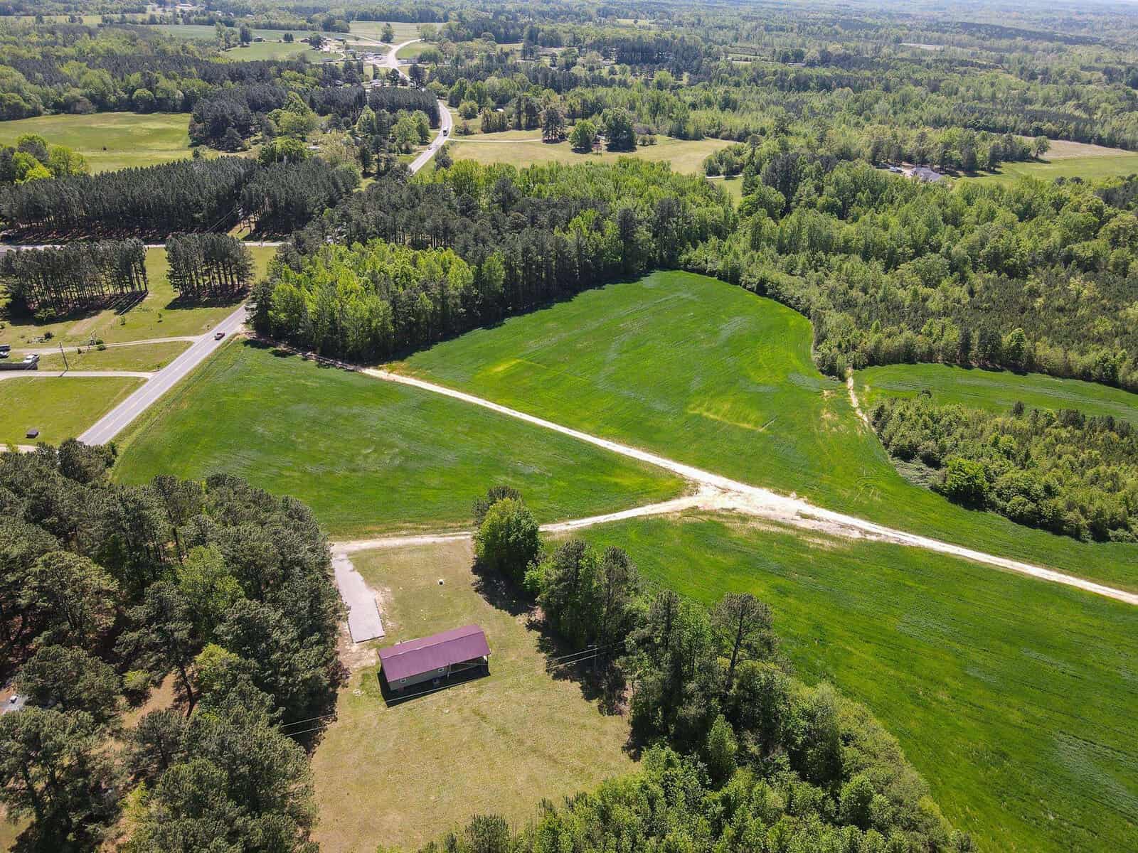 A green field with trees and a building.