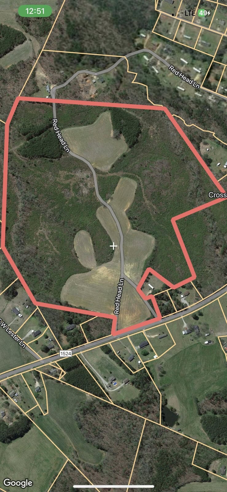 Satellite view of a rural area with a highlighted property boundary marked in red.