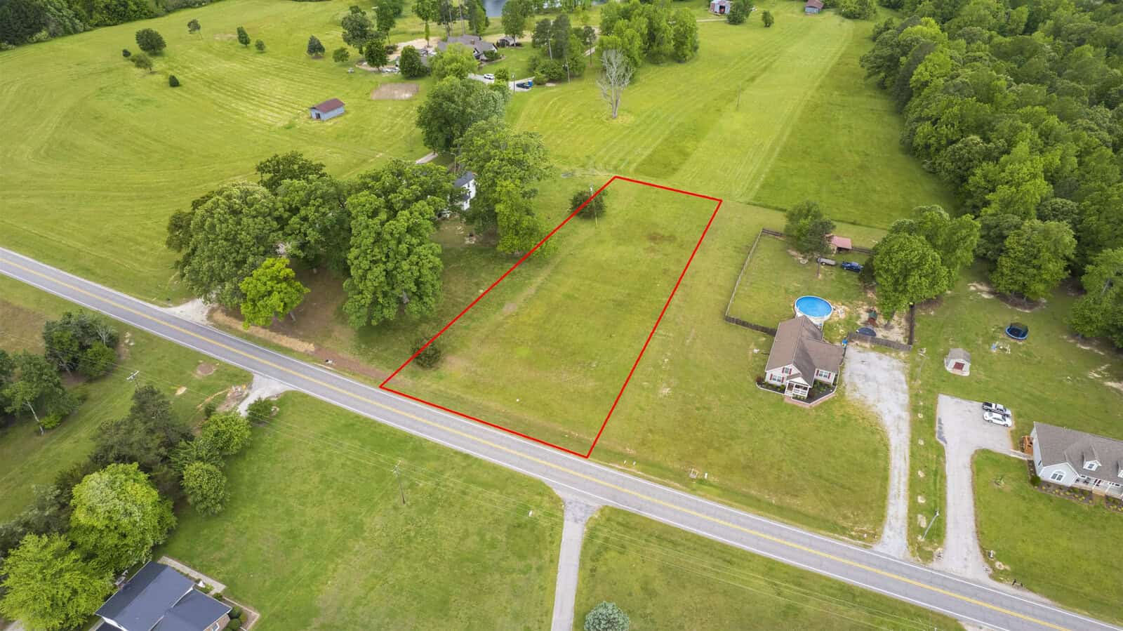 Aerial view of a delineated plot of land near 3217 Satterwhite Point Road, Henderson NC, with surrounding greenery and residential properties.