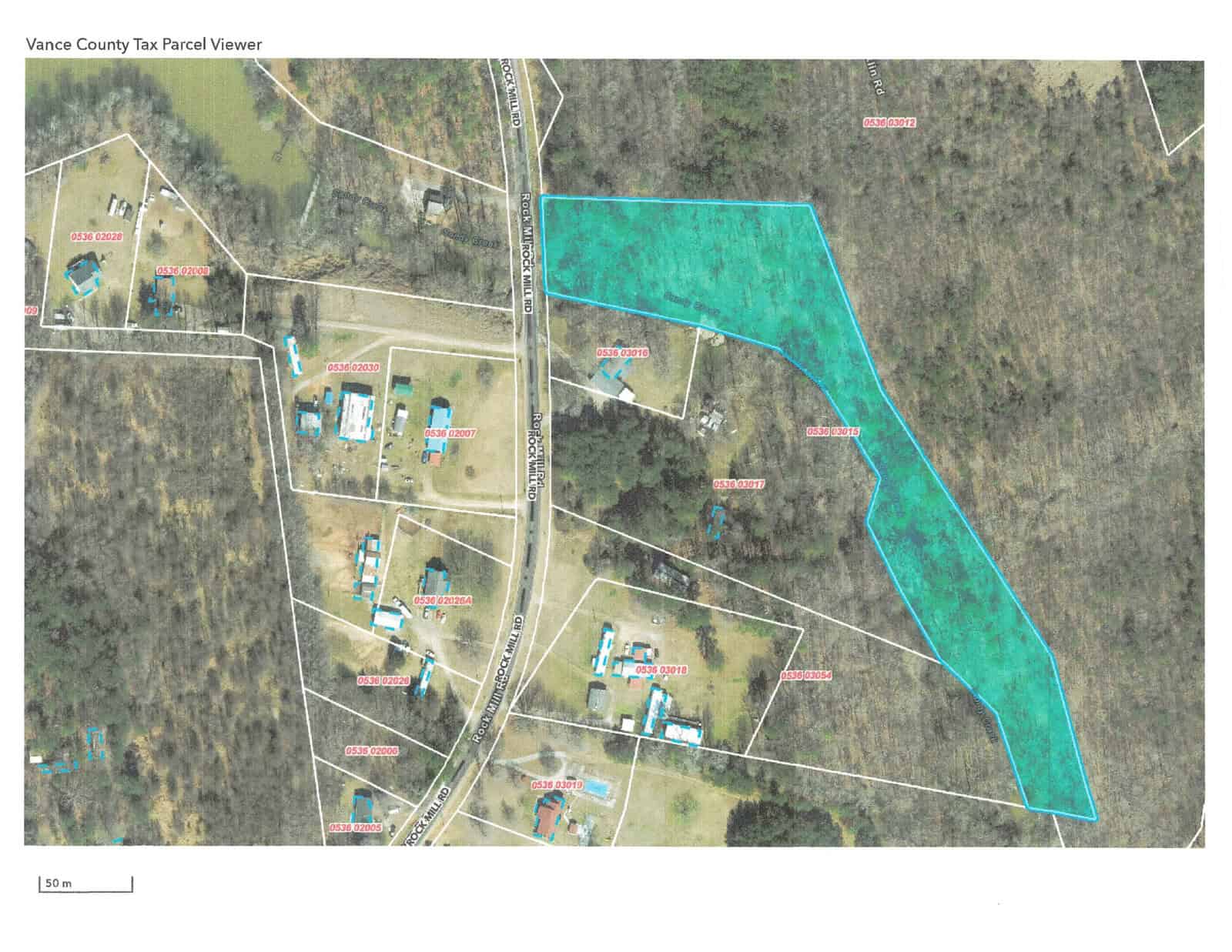 Aerial view of a rural area with properties demarcated, highlighting a specific parcel in blue.