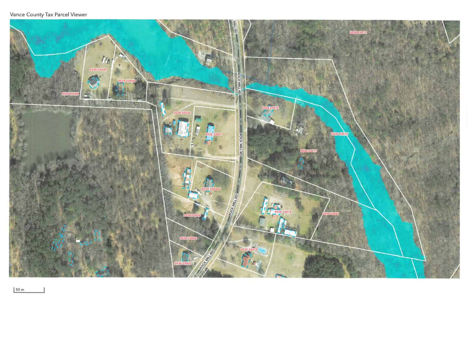 Aerial view of a rural area showing property boundaries and parcels with several houses near a body of water.