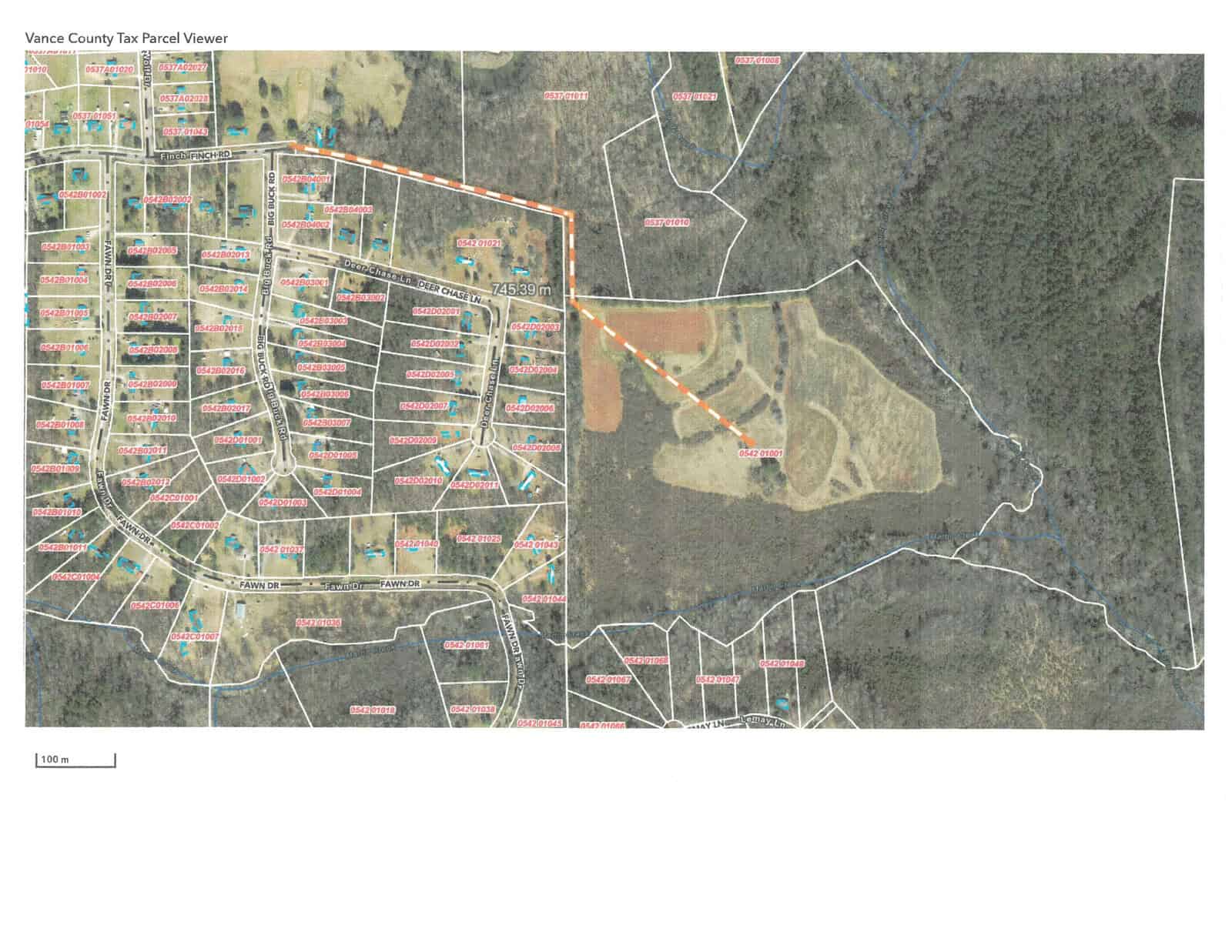 Aerial map view of a plotted residential area adjacent to undeveloped land with parcel boundaries and labels visible.