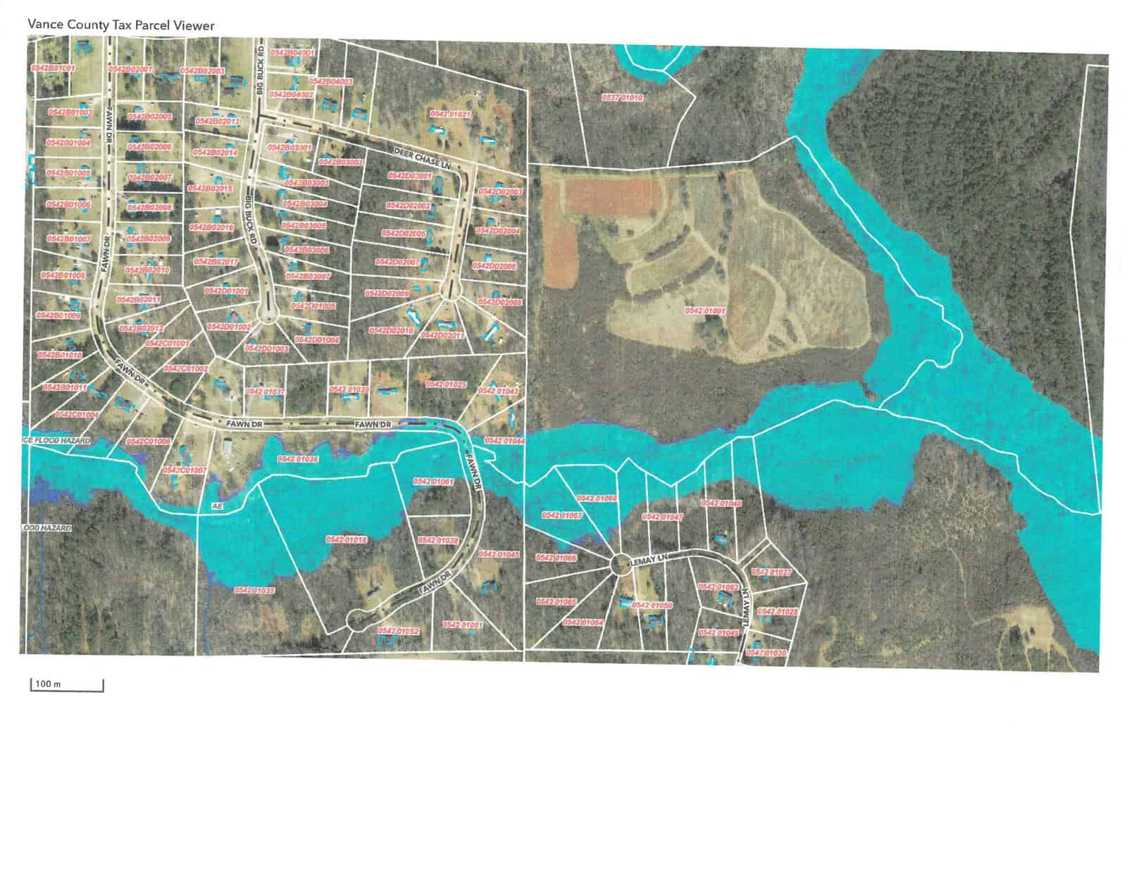 A colored map depicting the layout of a residential area with marked parcels, adjacent to a body of water.