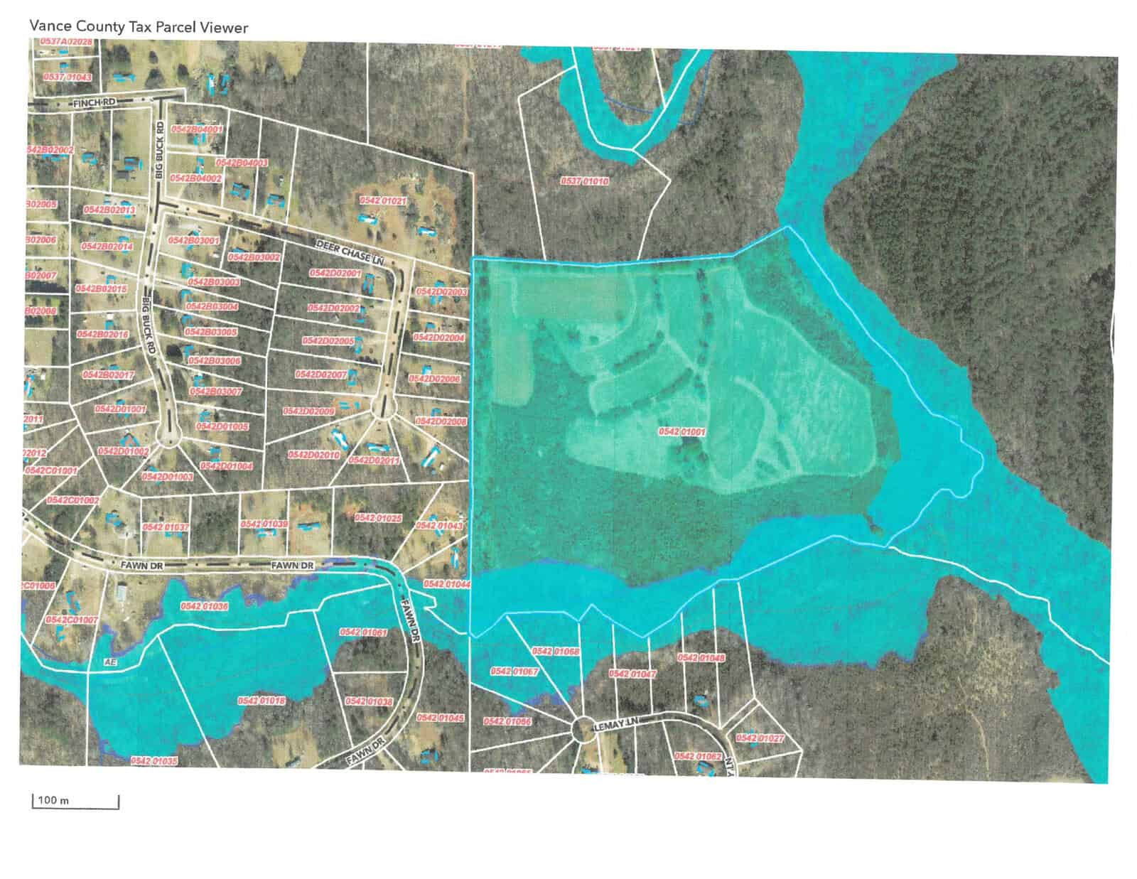 A color-coded land parcel map showing various plots of land with boundary lines and labels, adjacent to a body of water.