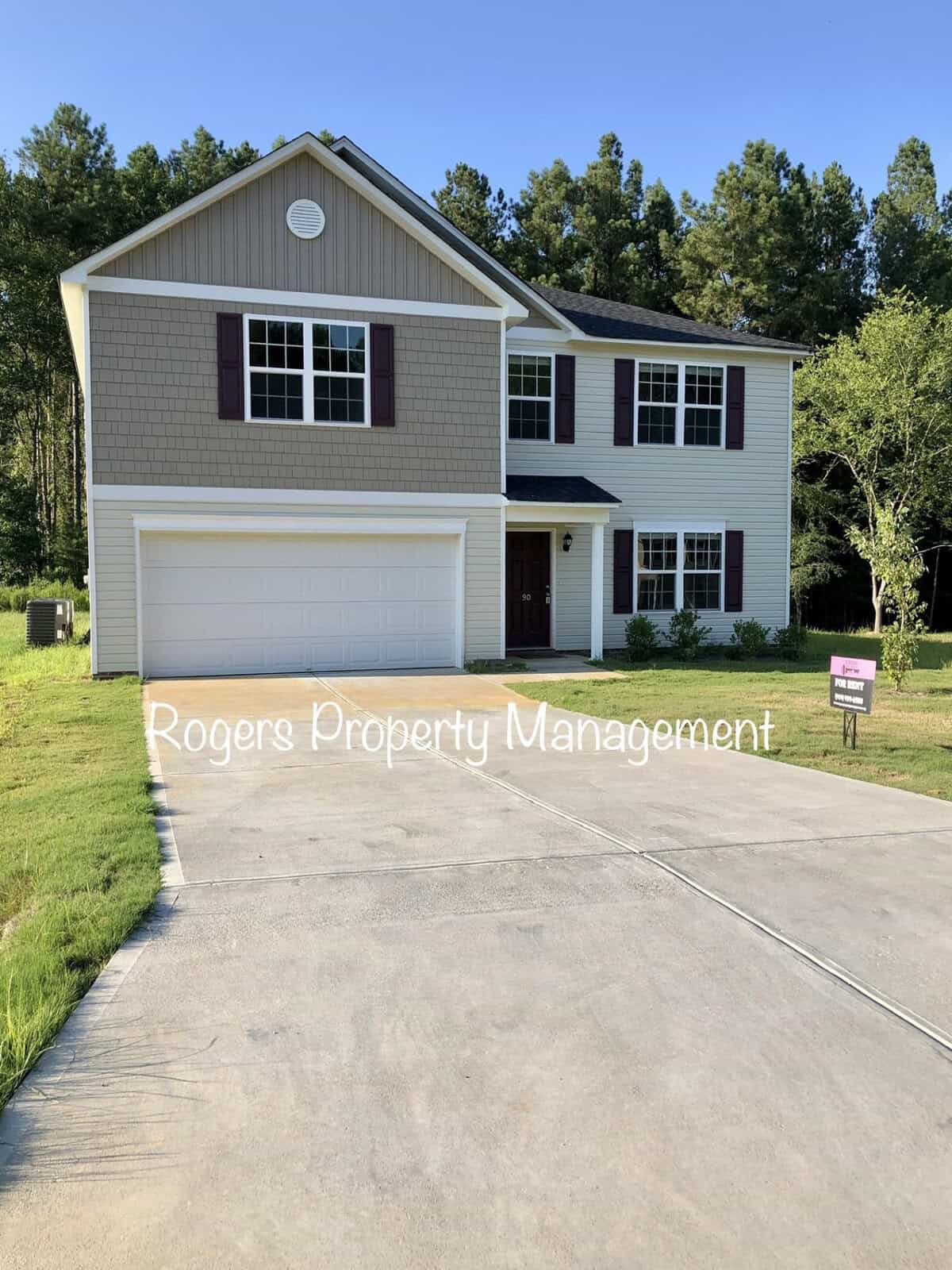 Two-story residential home at 90 W Boulder Drive, Henderson NC, with an attached two-car garage and a property management sign in the front yard.
