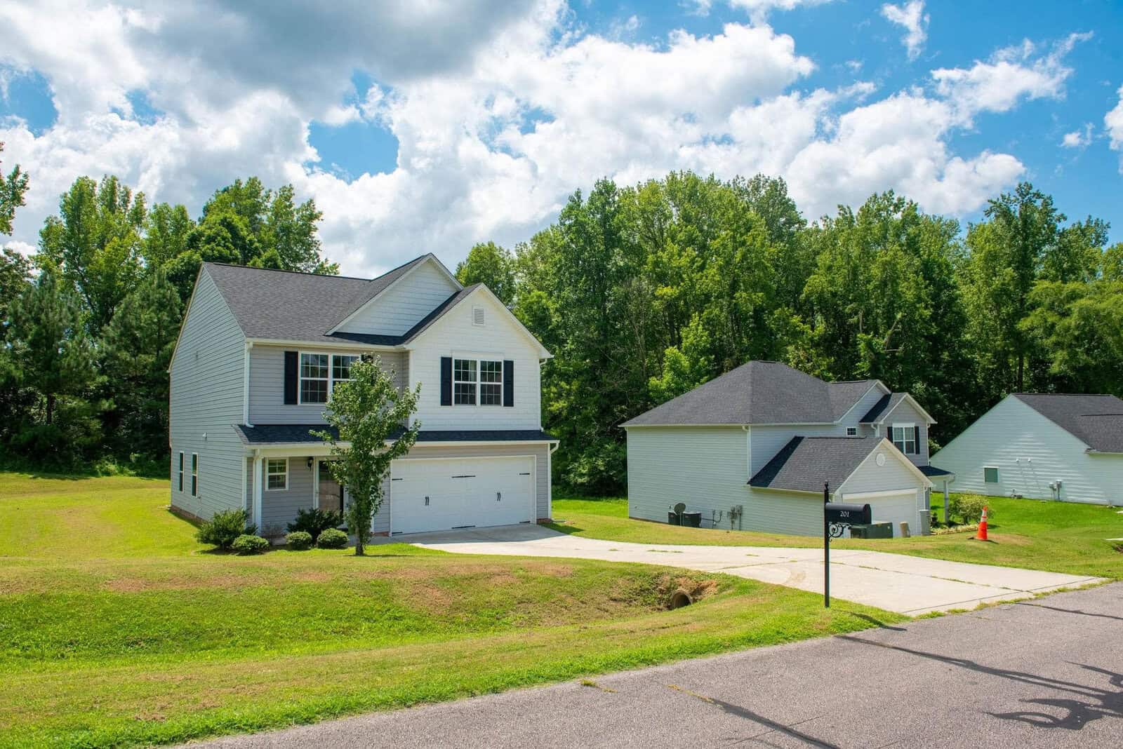 Suburban neighborhood with single-family homes, clear skies, and well-maintained lawns.