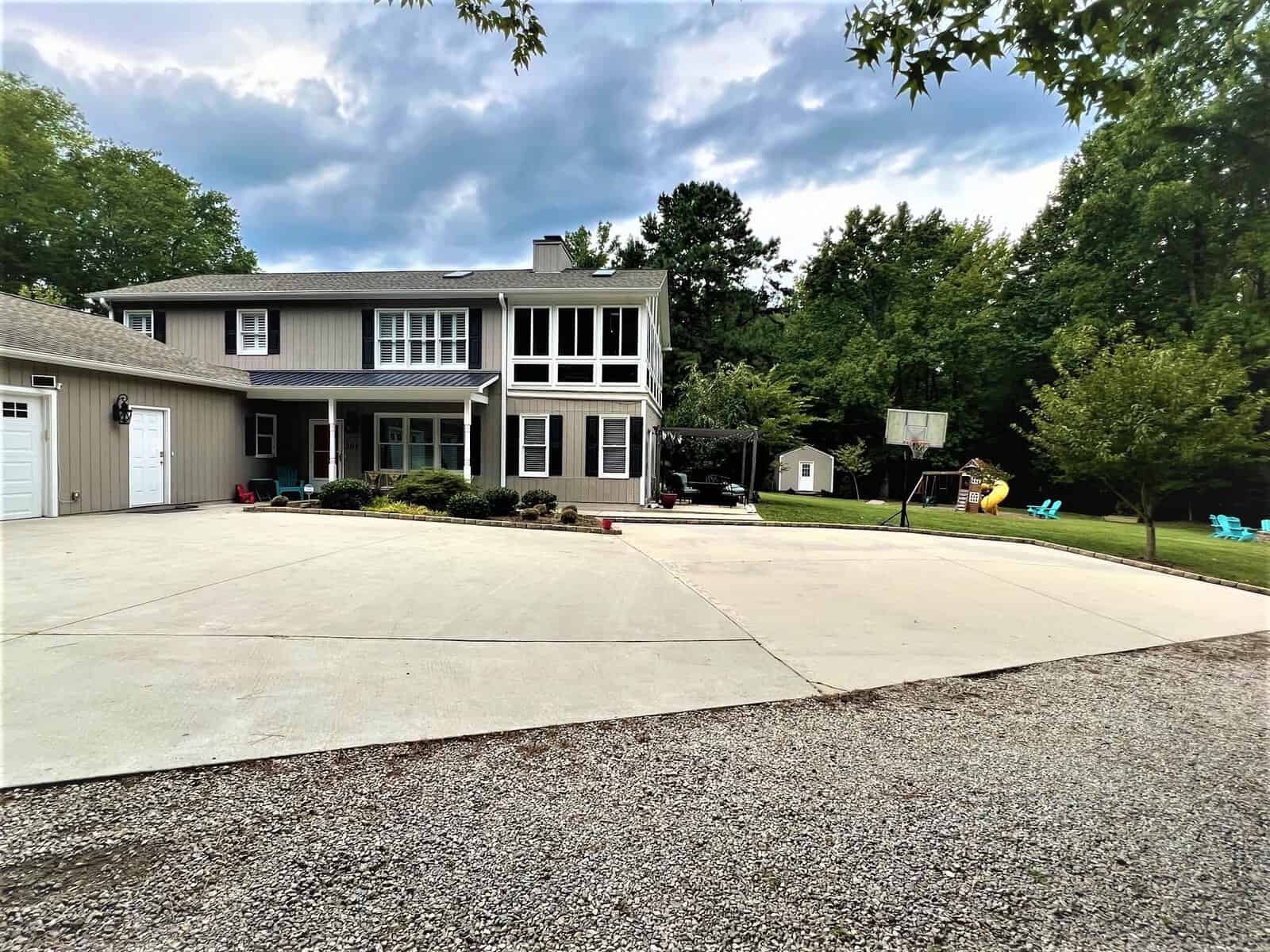 Description: A house with a driveway and a playground located at 301 Pebble Hill Lane in Henderson, NC.