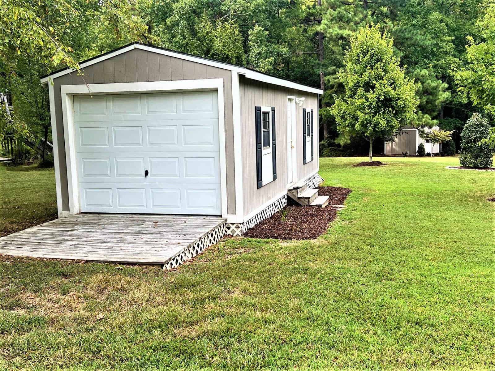 Located at 301 Pebble Hill Lane in Henderson, NC, this property features a versatile shed with an accompanying garage in the spacious back yard.