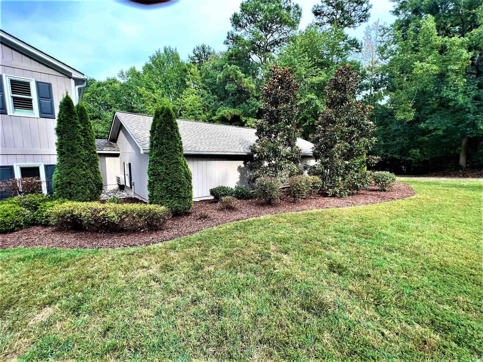 301 Pebble Hill Lane in Henderson, NC is a delightful property featuring a beautiful house surrounded by a well-maintained lawn and lush trees.