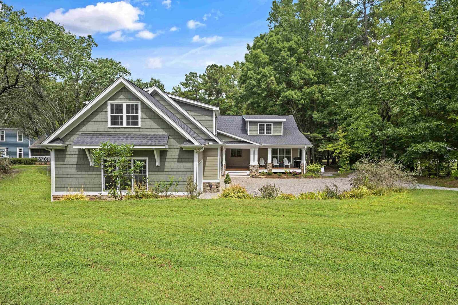 A single-story house at 386 Boyd Road, Henderson NC, with a gray exterior, white trim, and a covered porch, set against a backdrop of trees with a well-maintained lawn in