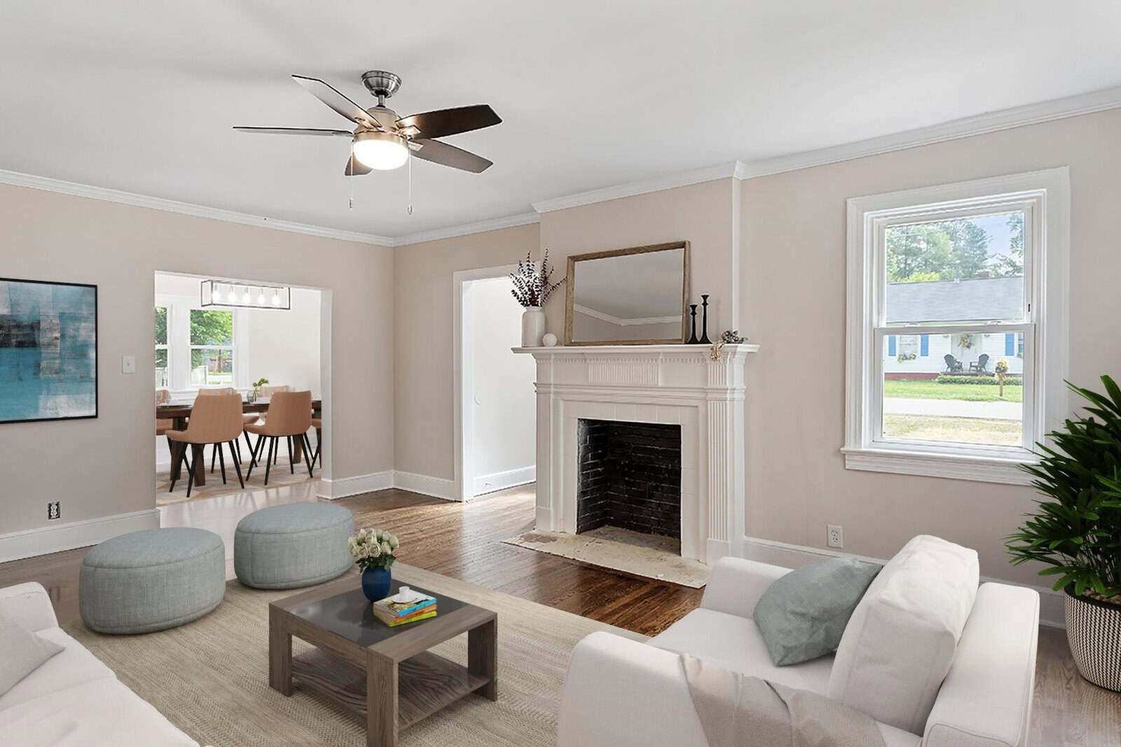 A neatly arranged living room with a fireplace, ceiling fan, and contemporary furnishings, including a sofa, armchairs, and a coffee table, with a view of the dining area in the background.