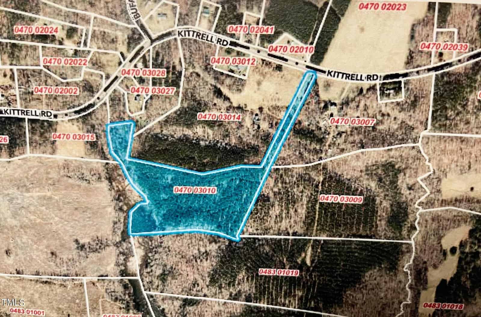 A map highlighting a property outlined in blue, located near the intersection of multiple labeled parcels and Kittrell Road. Various parcel numbers are visible, as well as wooded and open areas surrounding the highlighted property.
