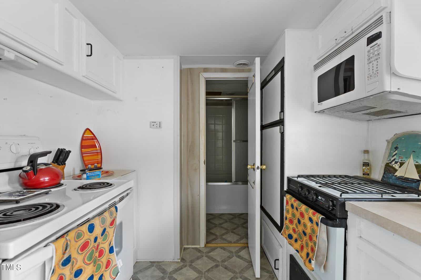 A kitchen with a microwave oven and oven door.